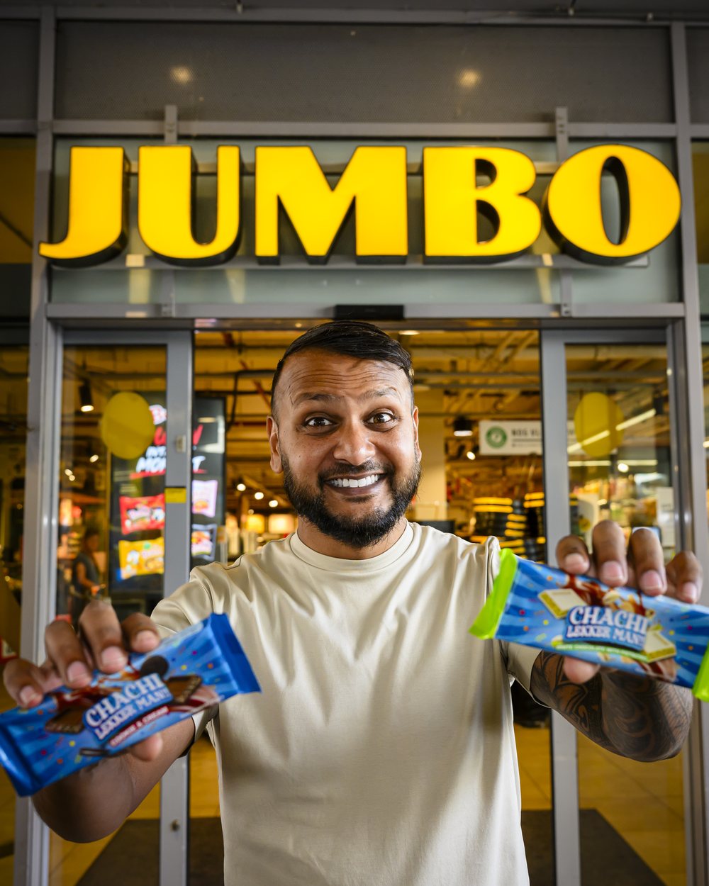 Cha Chi Versaci voor een Jumbo-winkel, met een CHACHI Cookie & Cream en een White Choco Pistache in zijn handen